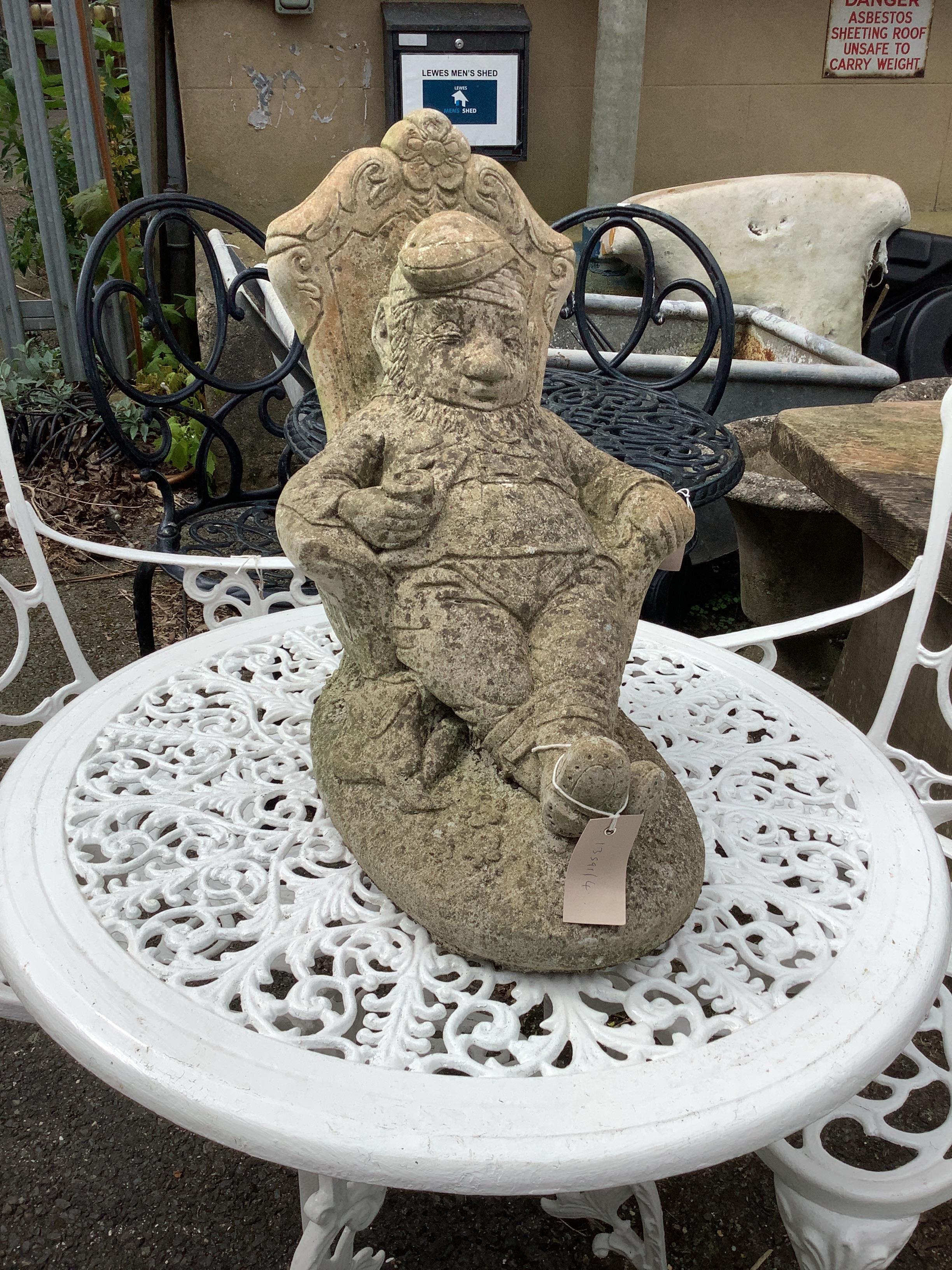 A reconstituted stone seated gnome garden ornament, length 40cm